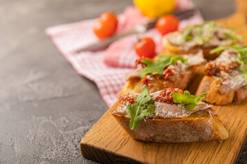 delicious bruschetta with salmon avocado and arugula on a wooden board.