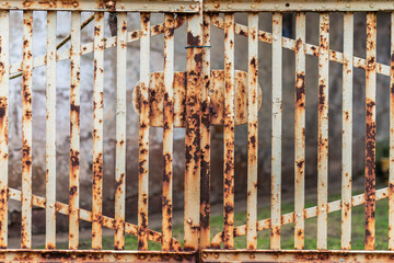a rusted white iron gate