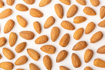 Almond pattern on beige background, top view