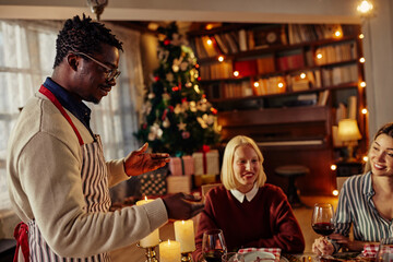 Multi ethnic group of friends having new year dinner party, everyone enjoying in food and drink