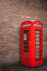 The traditional British public red telephone kiosk or booth with brick wall in the background, Bushmills town, Northern Ireland