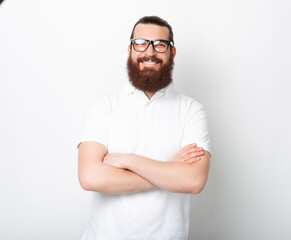Confident bearded man wearing glasses is smiling at the camera.