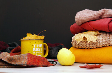 Autumn clothes stack on the table on a black background