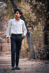 Fototapeta na wymiar Portrait of happy young businessman walking in park