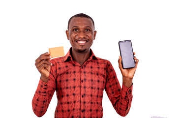Young man showing credit card and mobile phone smiling.