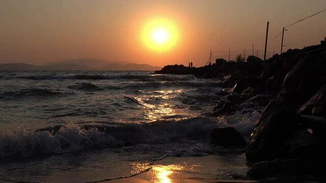 A stony pier and waves in the sea at sunset, Sevgi Beach, Kusadasi, Aydin, Turkey