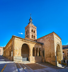 Obraz premium Principal facade and the entrance of the northern atrium of the Romanesque church of San Martin, with the tower bell in the background. View from Jose Canalejas street. Segovia, Spain.