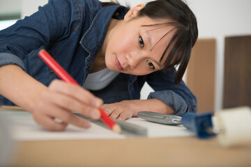 Naklejka na ściany i meble female engineer using pencil drawing