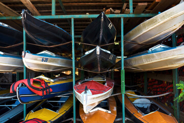 Collection of colorful kayaks on shelves in garage