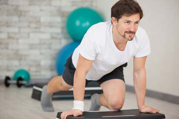 Fototapeta premium man doing step up jumps in health club