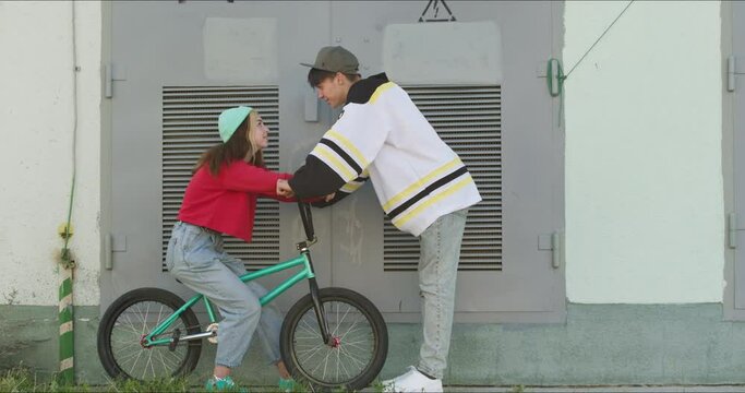 A loving couple of teenagers on a date. The guy is trying to kiss the girl. Young modern woman flirts with a man. 4k raw video footage