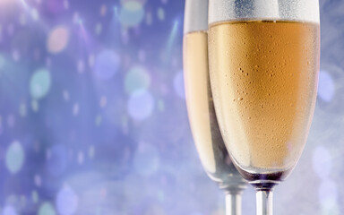 Two glasses of champagne against a background of bokeh spots. Christmas and New Year background. Selective focus.