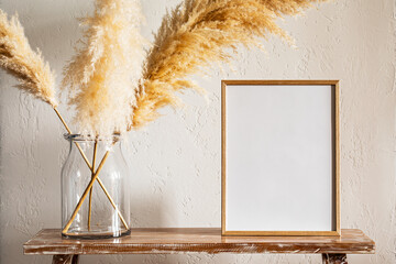 30x40 cm photo frame with pampas grass in a large jar on a bench near the wall