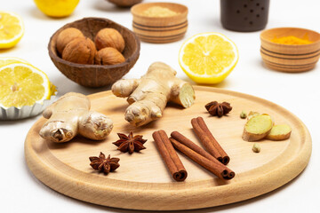 Cinnamon sticks, ginger root and star anise on cutting board.