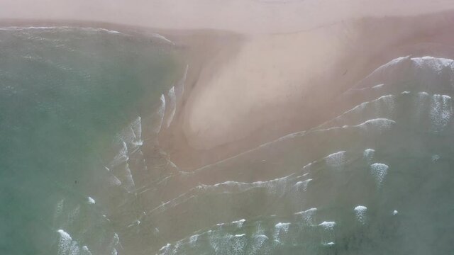 Waves from the Atlantic Ocean wash onto a scenic beach in Chatham, Cape Cod, Massachusetts. This beautiful peninsula is a popular vacation destination during summer months.