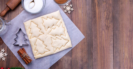 Making Christmas tree shaped puff pastry cookies with sugar and cinnamon, top view, copy space