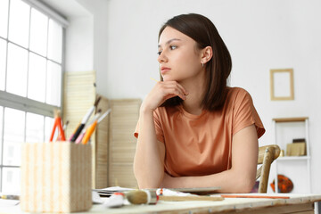 Young female artist at table in workshop