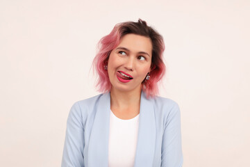 A girl with pink hair, happily winking and showing a perfectly white smile, sticking out her tongue, stands on a white background.