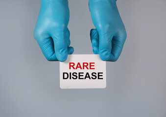 Rare disease concept. Word on paper in hands.