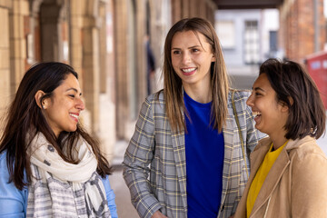 Multiracial group of girls walking in the city. Urban background with busy road and sidewalk, friendship and lifestyle concepts.Group consists of indian, asian and caucasian girls. High quality photo