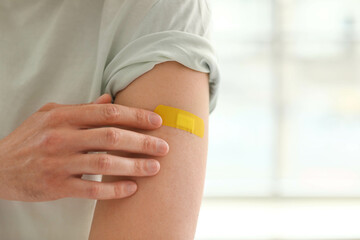 Man with medical patch on his arm, closeup