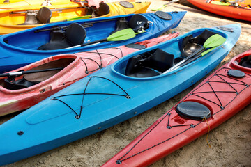 Collection of kayaks with paddles on coast