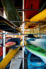 Set of different water kayaks on shelves