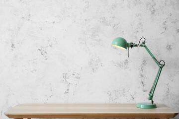 Green lamp on table near light wall