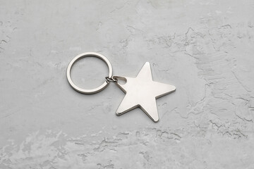 Silver star shape keychain on grey background