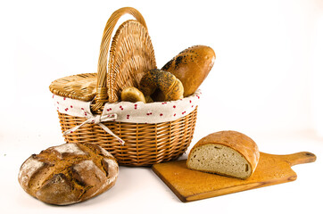 Basket with bread and whole wheat bread on white background. Sliced bread on board