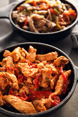 Frying pans with tasty Fajita on table, closeup