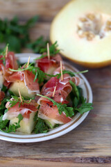 Appetizer with prosciutto and melon. Healthy food. Summer snack. The keto diet.