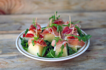 Appetizer with prosciutto and melon. Healthy food. Summer snack. The keto diet.