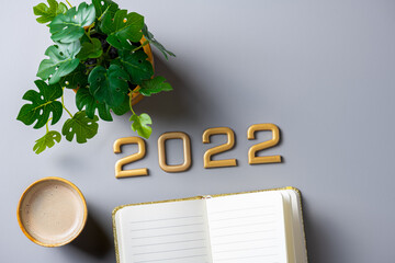 New year goals 2022 on desk. 2022 new year resolutions on gray table with coffee cup, notebook and...