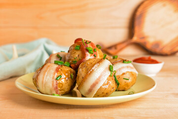 Plate of tasty baked potatoes with bacon on wooden background