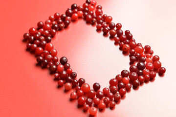 Frame made of tasty fresh cranberries on color background