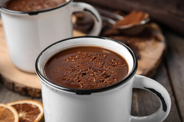 Cups of tasty hot chocolate on wooden background, closeup