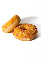 Orange donut decorated with colorful sprinkles isolated on white background. Mango flavor, very tasty and original. Novelty concept.