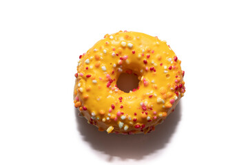 Orange donut decorated with colorful sprinkles isolated on white background. Mango flavor, very tasty and original. Novelty concept.