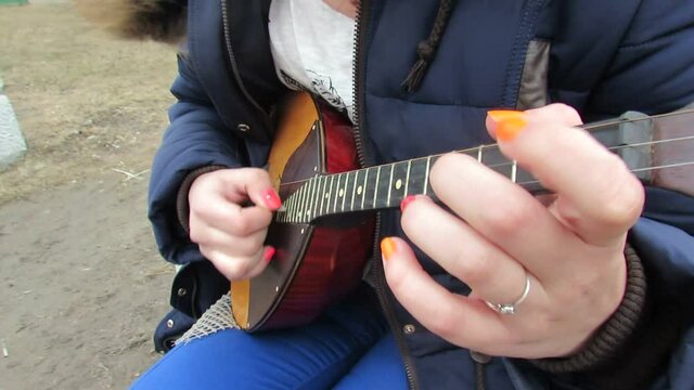 The girl plays the dombra and deftly fingering.