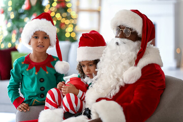 Fototapeta na wymiar Little African-American children with Santa Claus at home