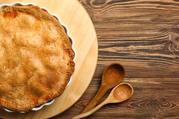 Baking dish with tasty chicken pot pie on wooden background, closeup