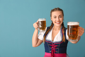 Young Octoberfest waitress with beer on blue background