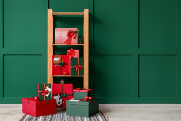 Christmas gift boxes and shelving unit near green wall