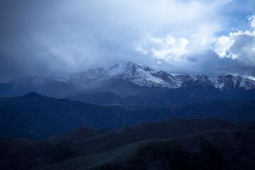 Pikes Peak Colorado snow capped mountain range with storm clouds