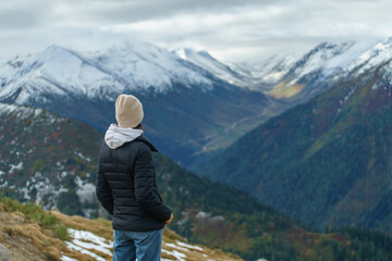 Back view of millennial young woman on top of mountain
