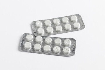 Medical tablets in blister foil packaging on a white background