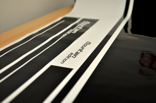 Brno, Czech Republic - 02 May 2020: Production of stickers on a cutting plotter intended for a vehicle from black foil