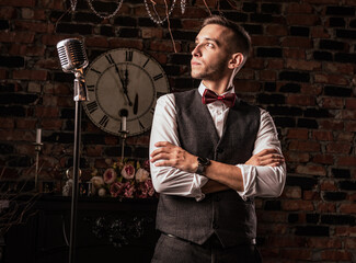 man in suit posing with condenser microphone. Emotional young man with a microphone in his hands