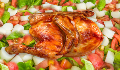 Delicious half roast chicken over colorful salad.